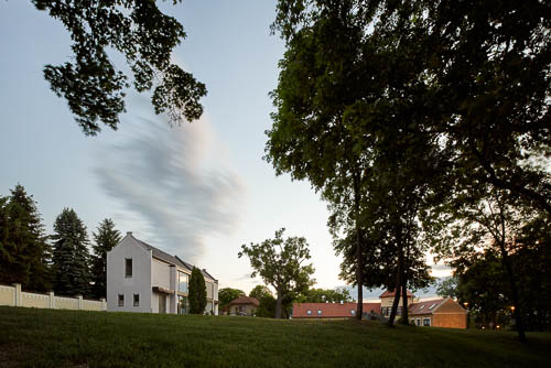 Dynamický exteriér rodinného dvoudomku u Prahy pro zahraničního architekta. Fotografie architektury skvělte prezentuje okolí a kontext.