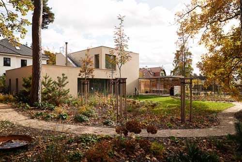 Architektura rodinného domu u Prahy s velkou zahradu v lesním městě daleko od lidí. Dvoupatrový dům od AIR Ateliér. Kontextuální architektonická fotografie ukazující okolí je ta nejlepší.