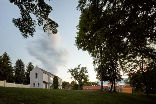 Dynamický exteriér rodinného dvoudomku u Prahy pro zahraničního architekta. Fotografie architektury skvělte prezentuje okolí a kontext.