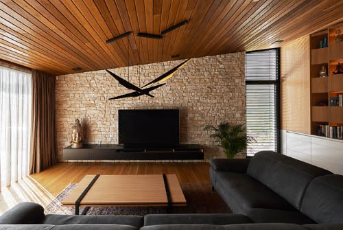 Pohled do interiéru obývacího pokoje s unikátním lustrem a televizí.