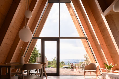 Interiérový design chaty u lesa s velkoformátovým prosklením.