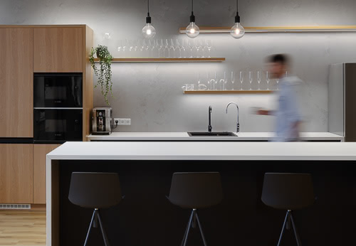 Kancelářské prostory ve Filadelfii v Praze pro interiérové studio zaměřující na kanceláře Capexus. Ve fotografii interiéru vidíme kuchyni a samotného architektka. 